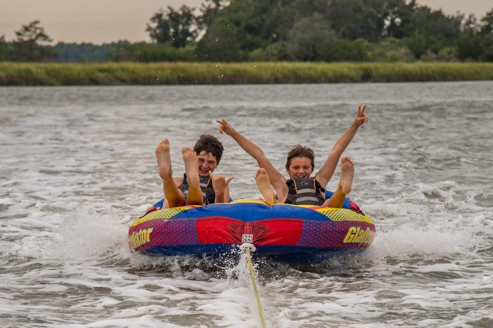 a man riding on the back of a boat in a body of water