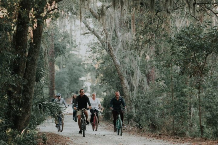 People biking down a road