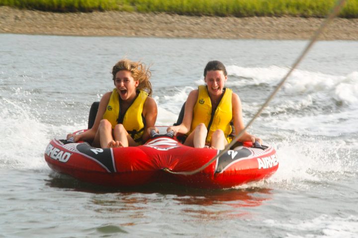 a man riding on the back of a boat in the water