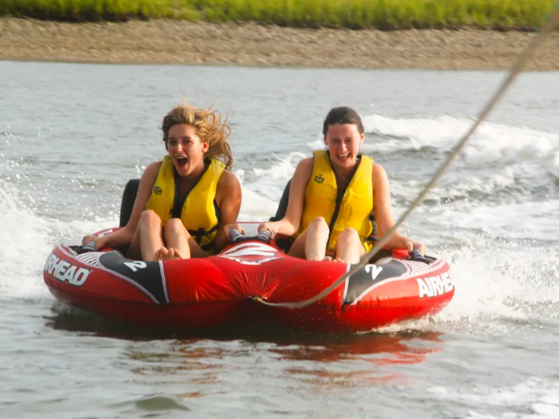 a man riding on the back of a boat in the water