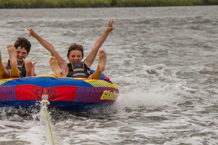 a person riding on the back of a boat in a body of water