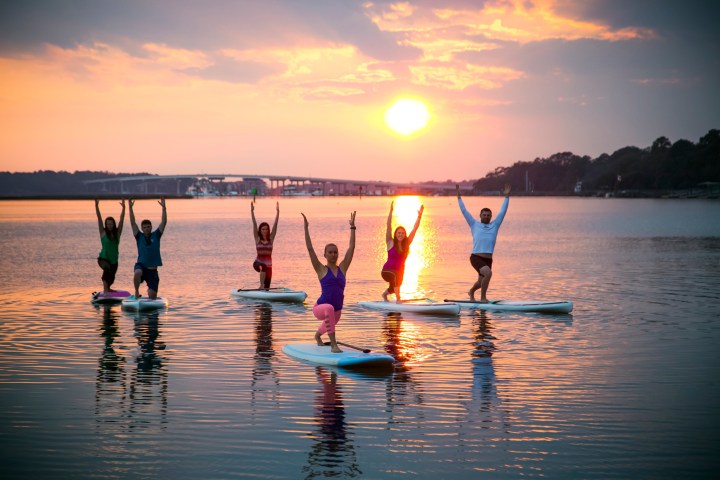 a group of people standing next to a body of water